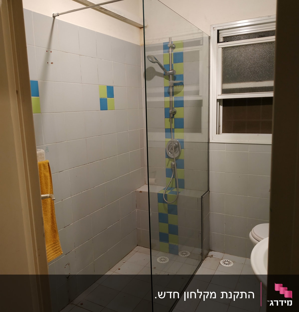 מקלחון זכוכית עם דלת שקופה בחדר אמבטיה